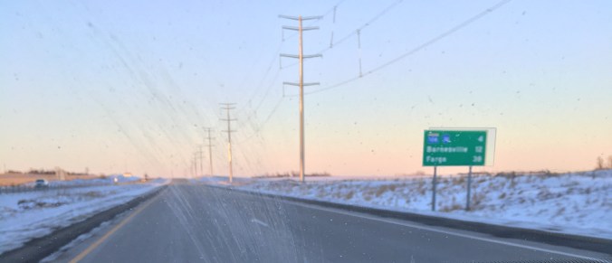 A slightly dirty windshield and iPhone mounted near the dash.